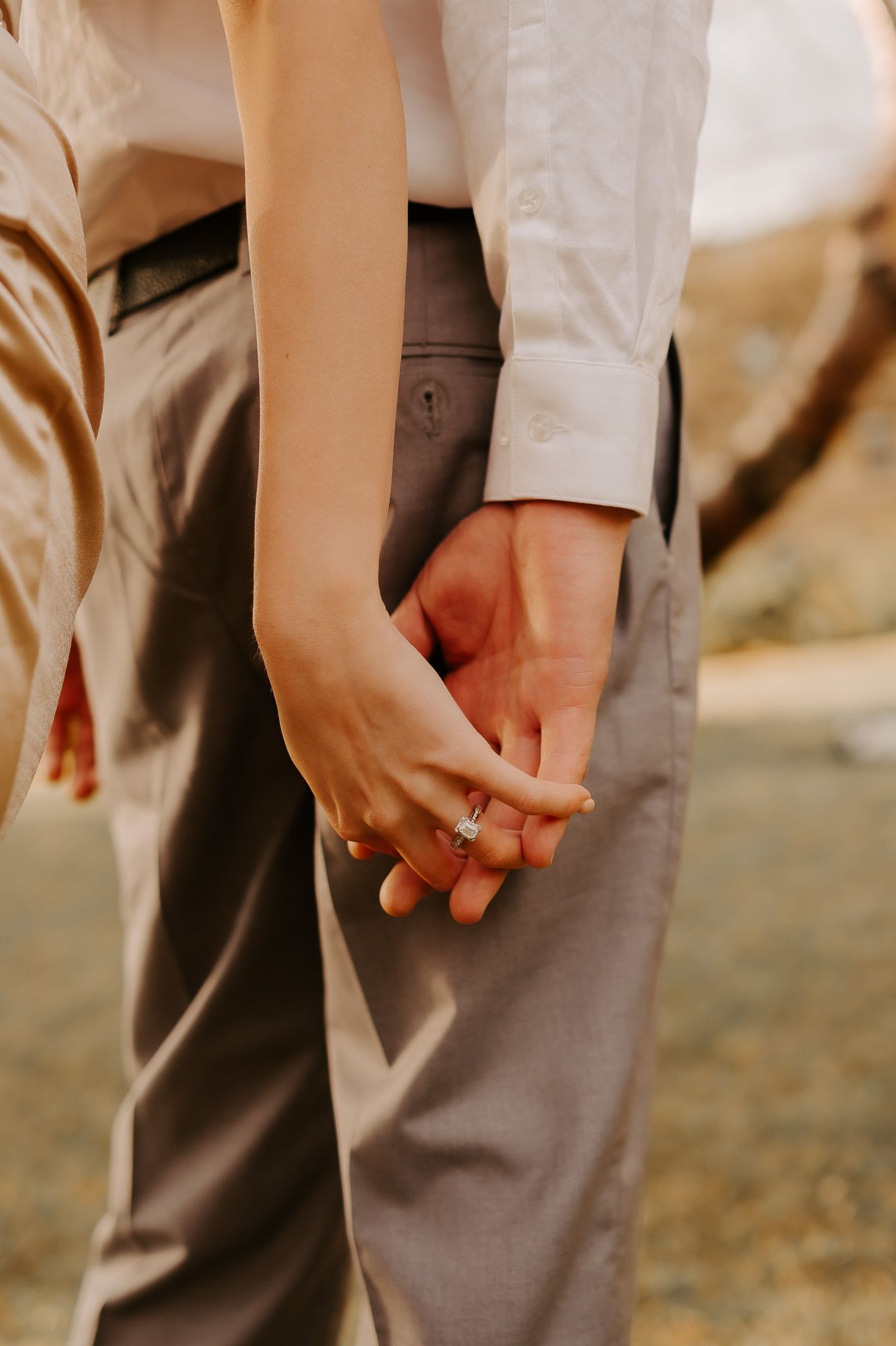 A man and a woman are holding hands in a field.