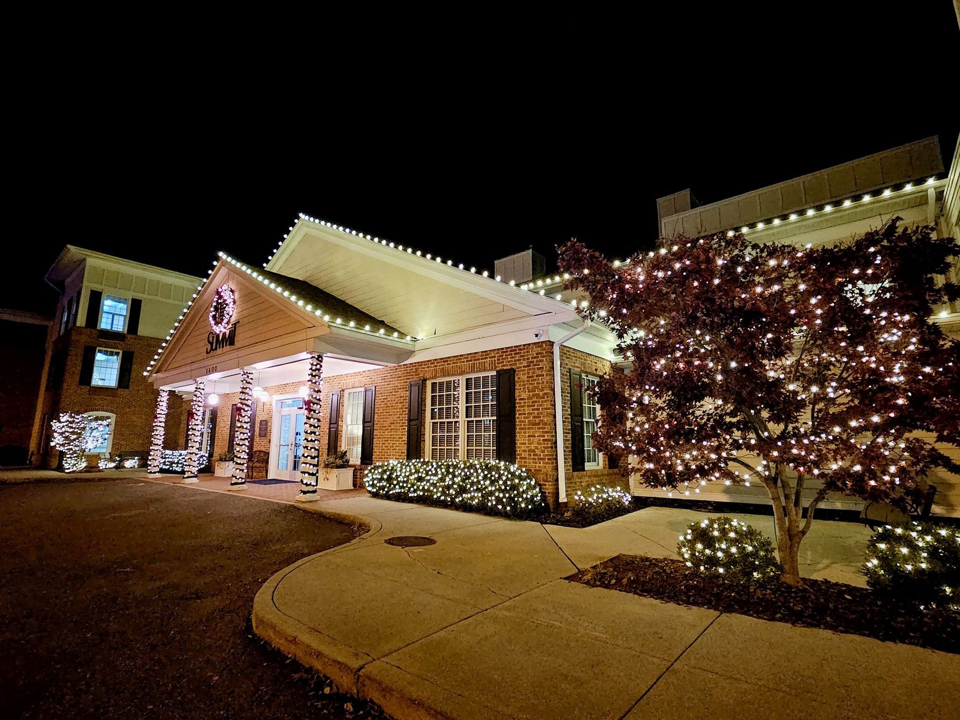 Building decorated with white Christmas lights at night.