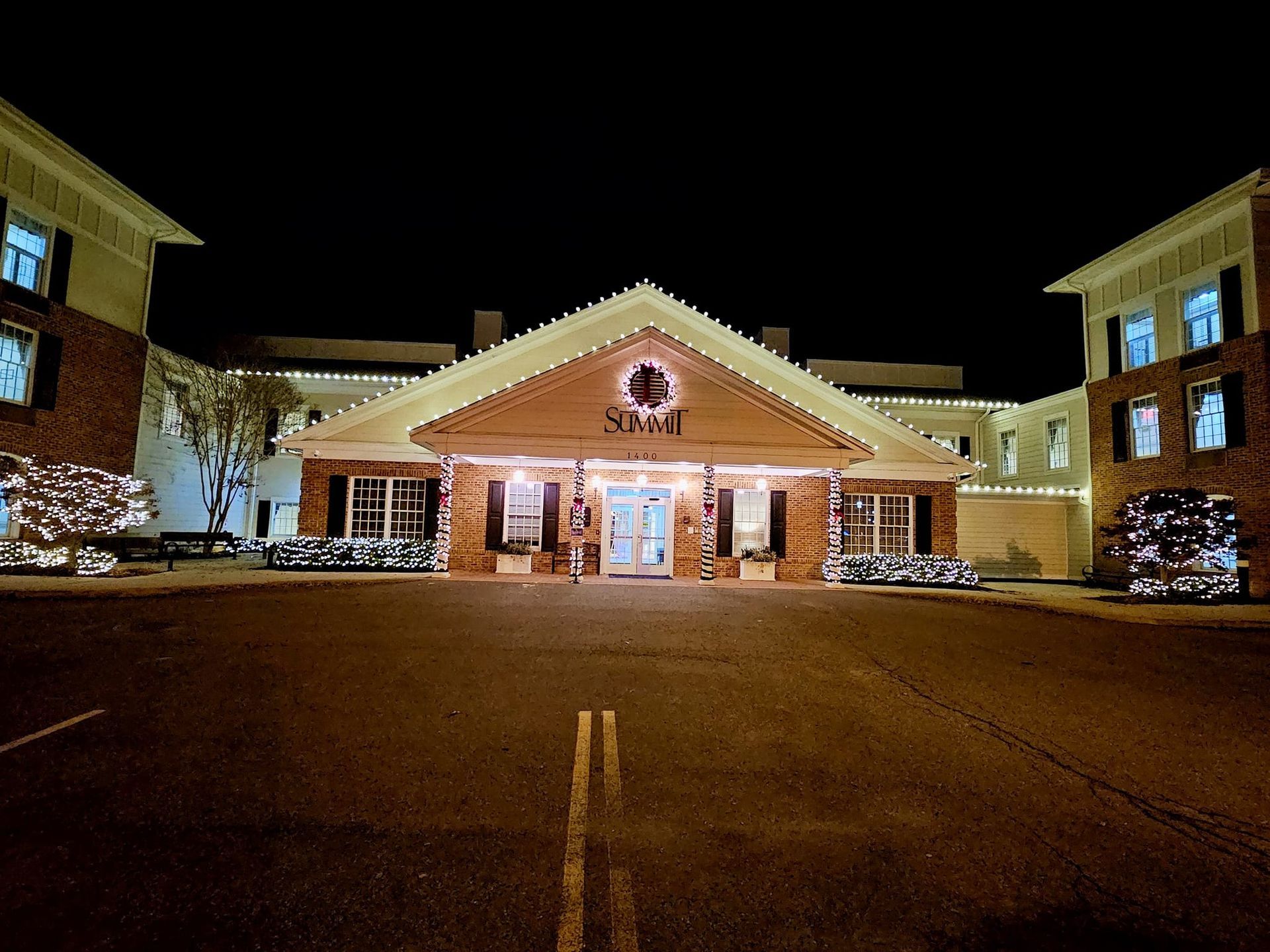 A building at night, lit with string lights. 