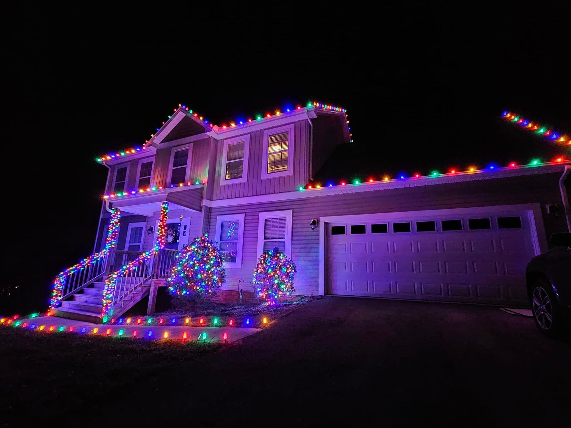 A house at night, illuminated with colorful Christmas lights.