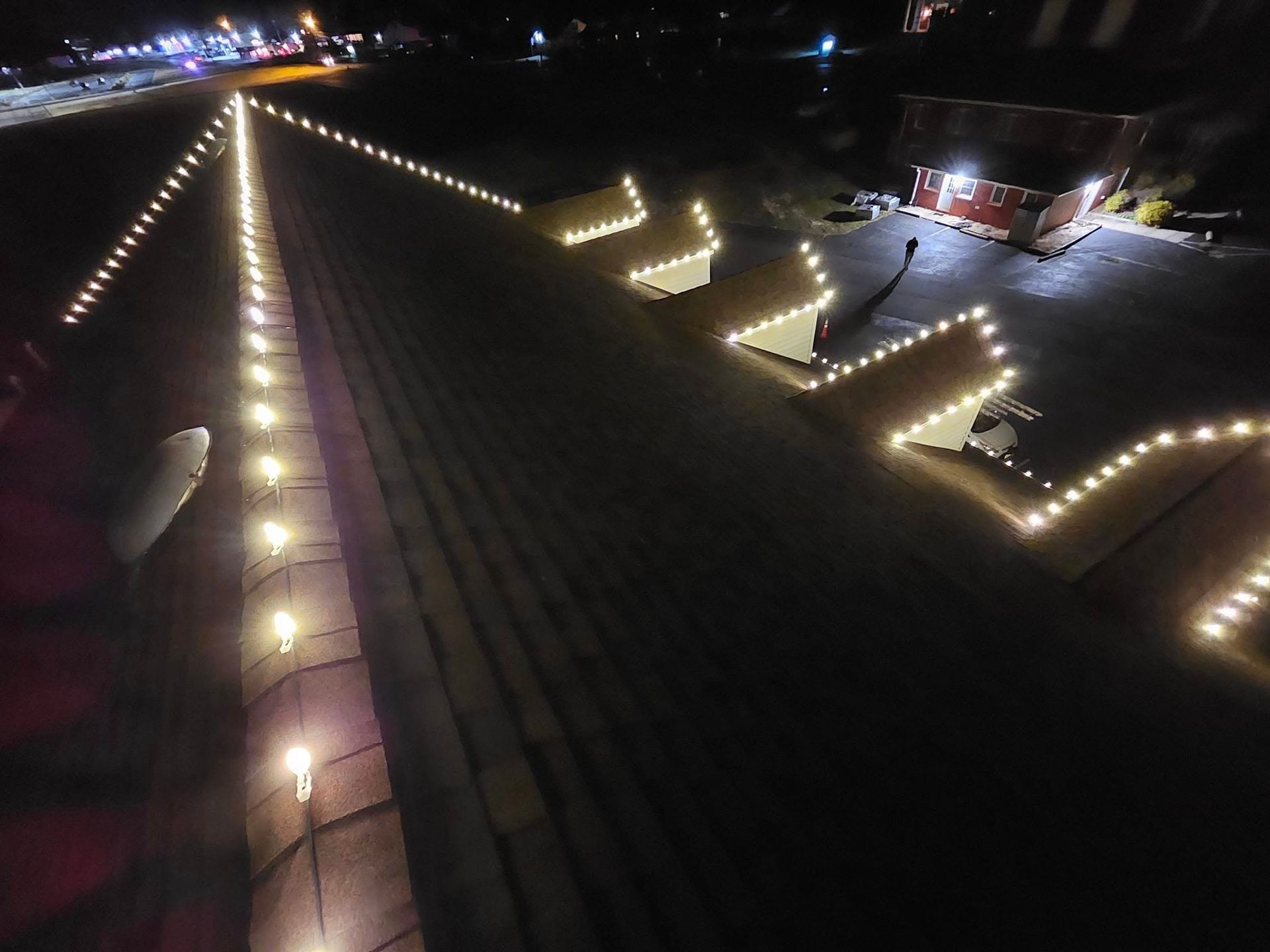 Night view of buildings with lit edges, row of lights down the center.