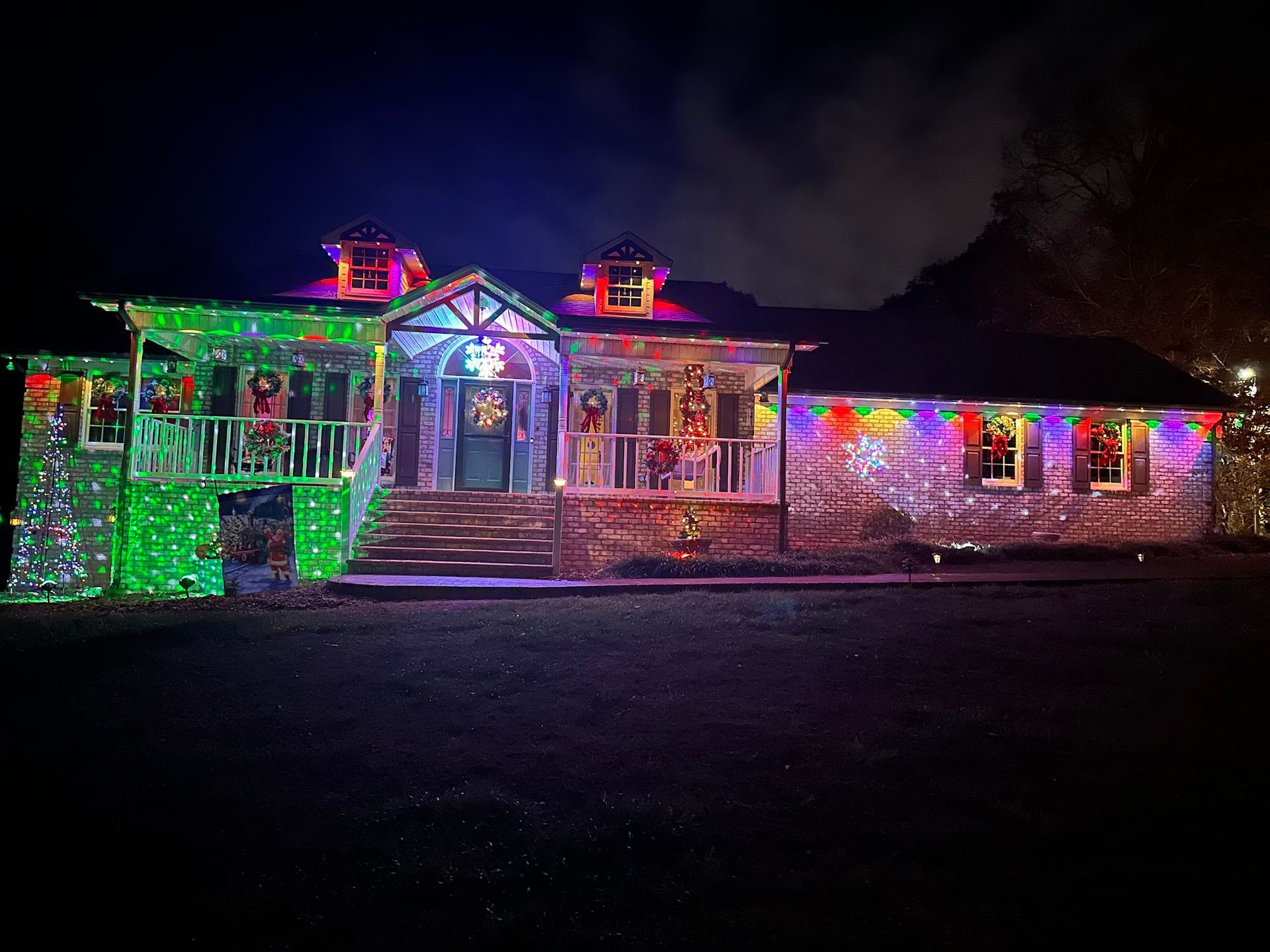 House covered in colorful Christmas lights at night.