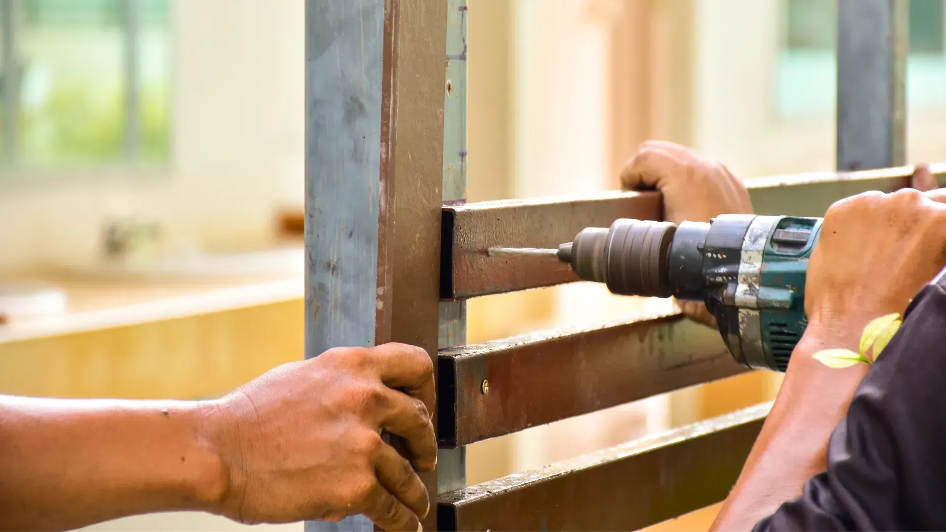 A man is using a drill to drill a hole in a piece of wood.
