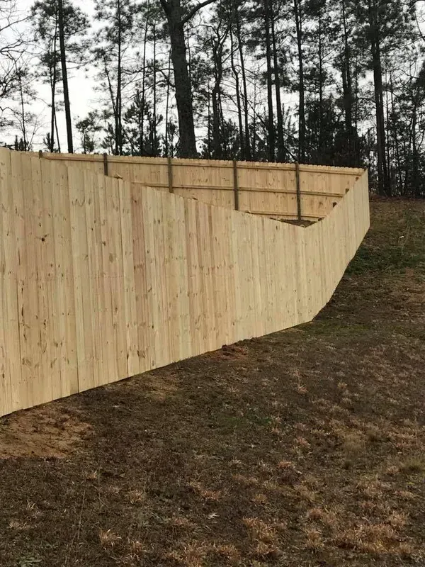 A wooden fence is sitting on top of a grassy hill.