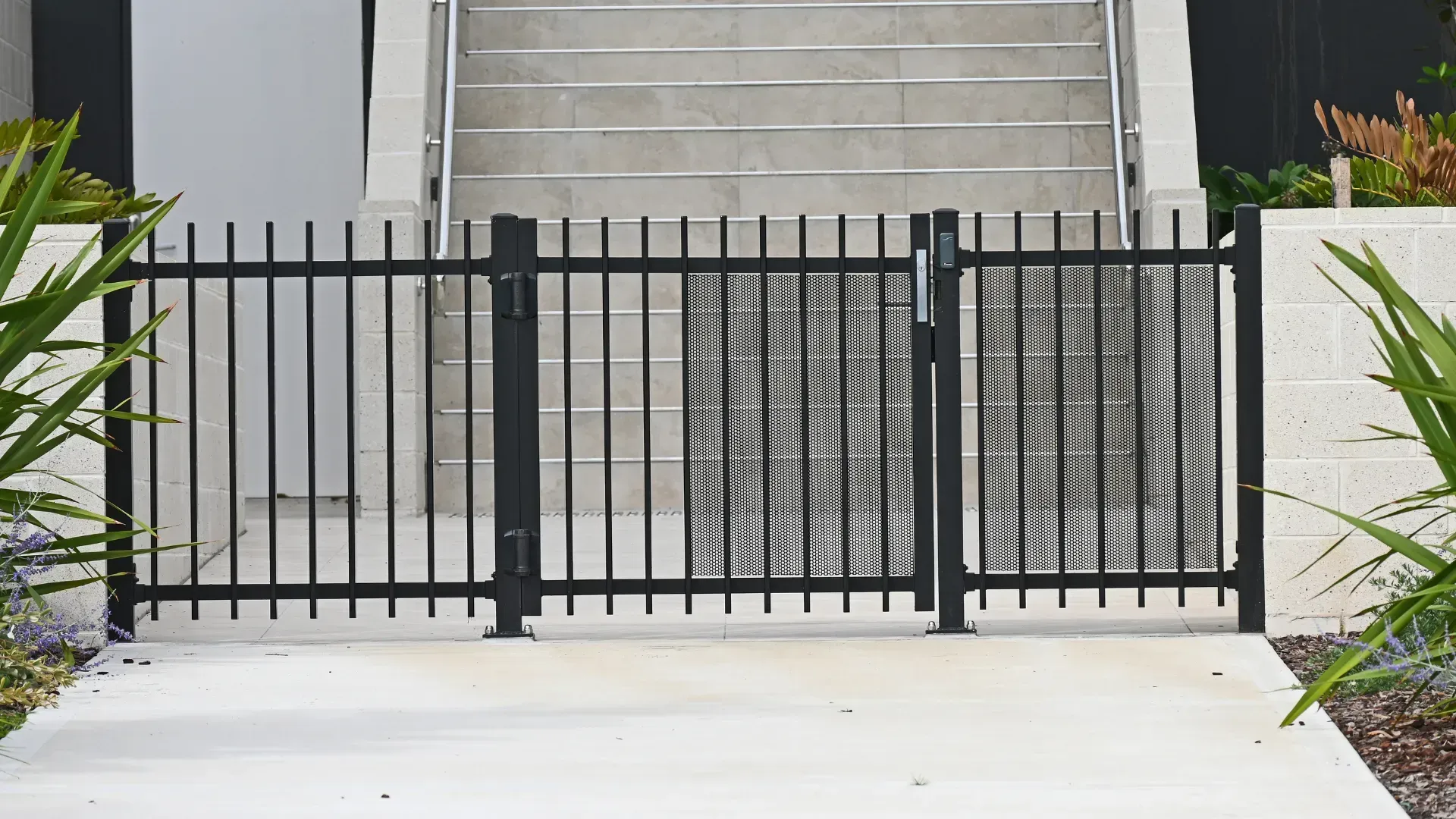 A black fence with a gate in front of a building.