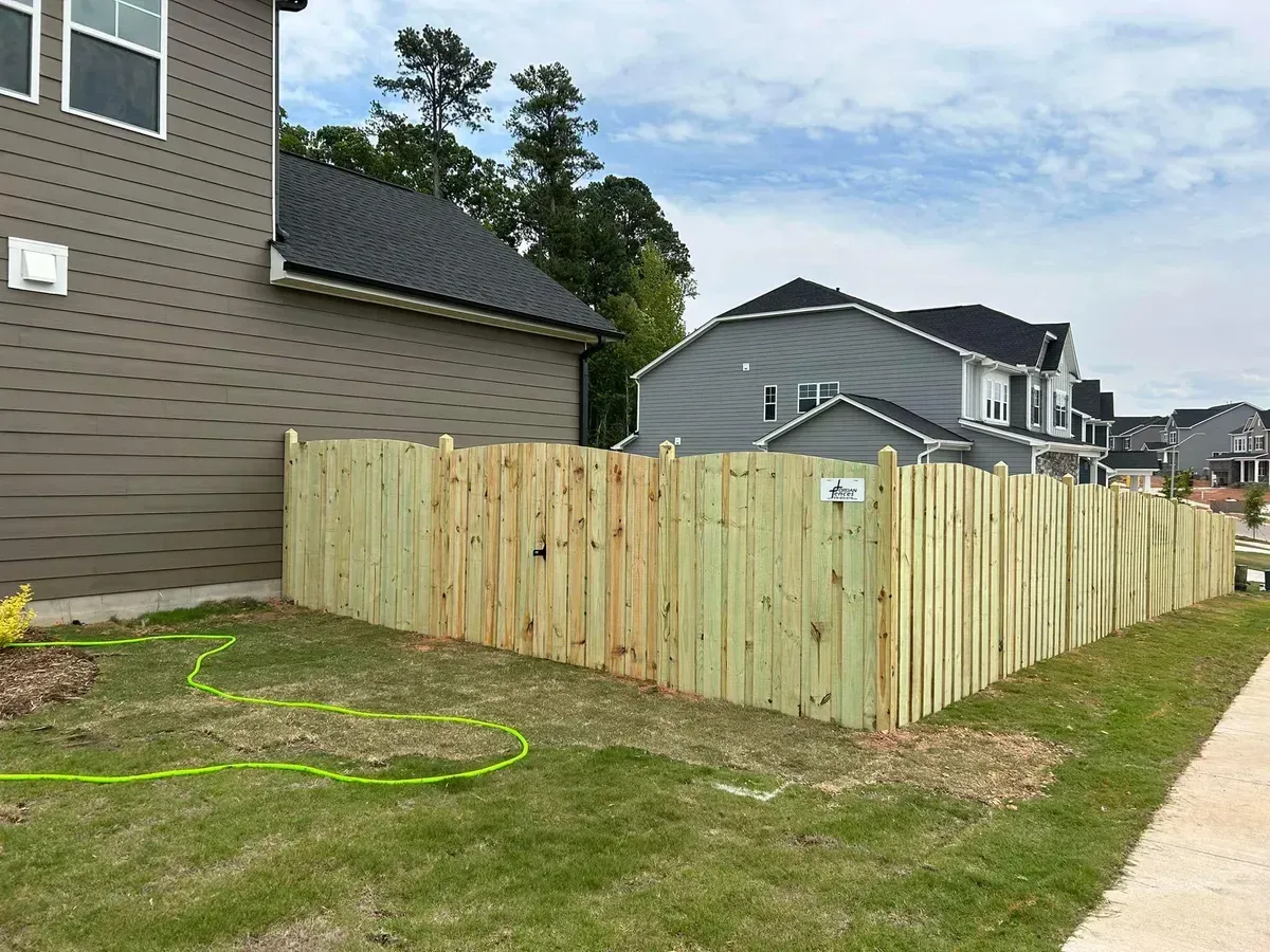 A wooden fence is being built in front of a house.