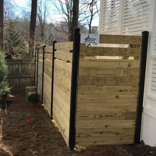 A wooden fence is sitting next to a house.