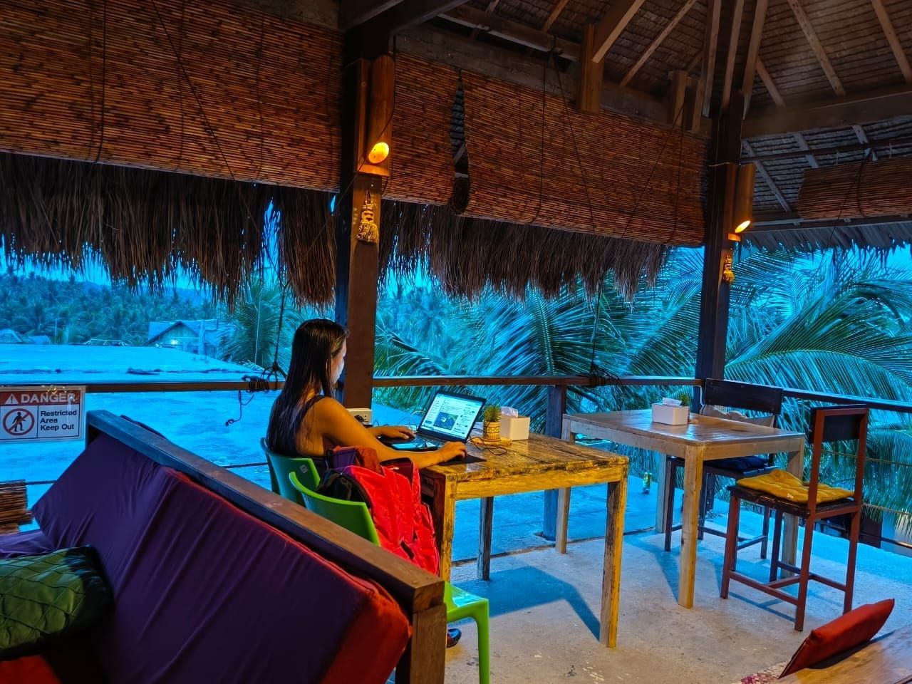 A woman is sitting at a table with a laptop.