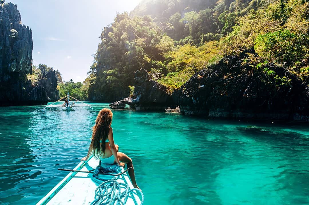 A woman is sitting on a boat in the ocean.