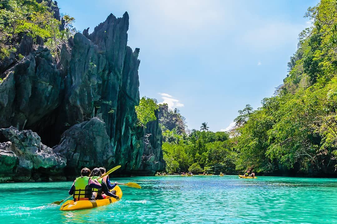 A group of people are riding a kayak down a river.