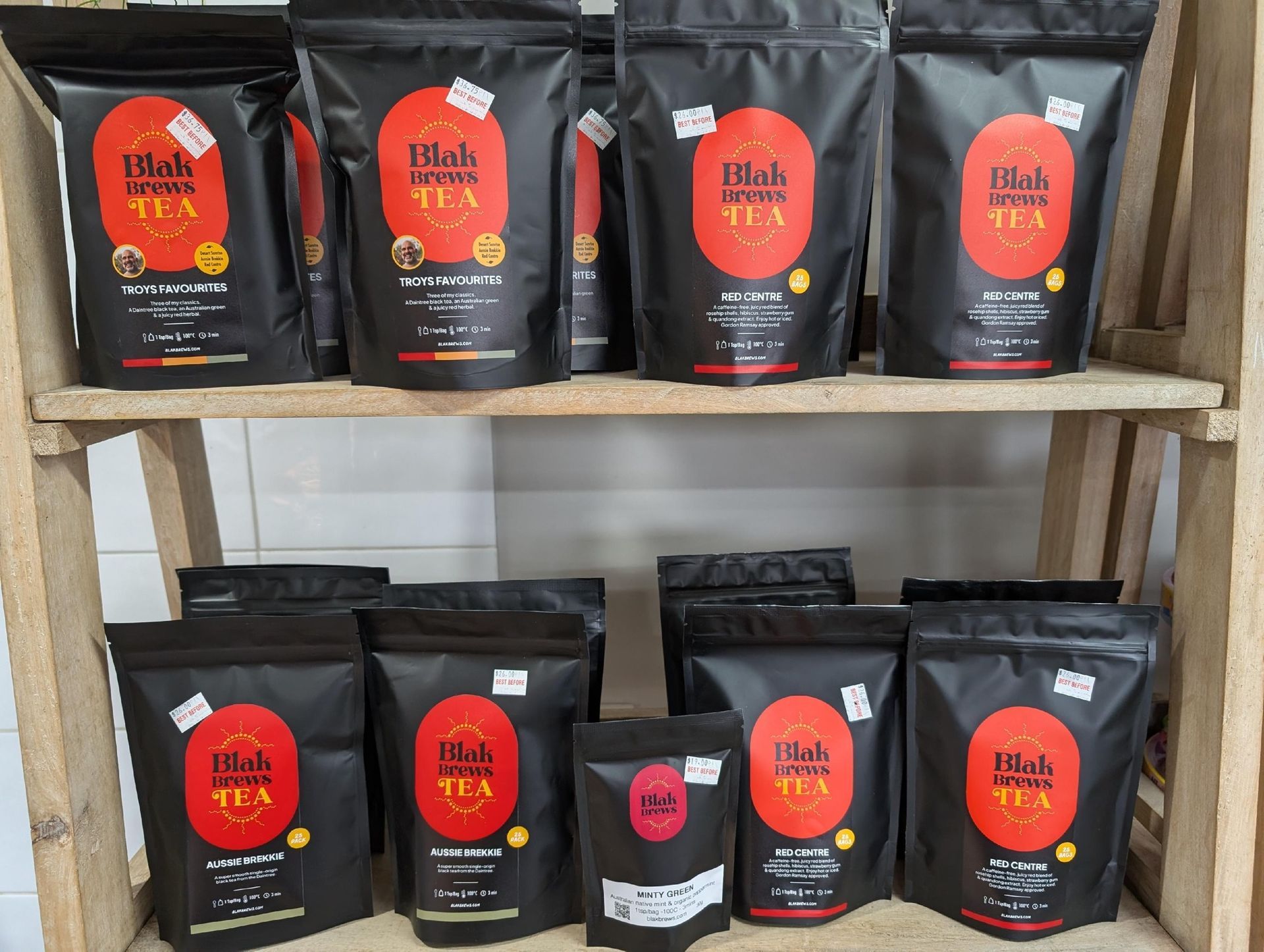 A wooden shelf filled with bags of tea.