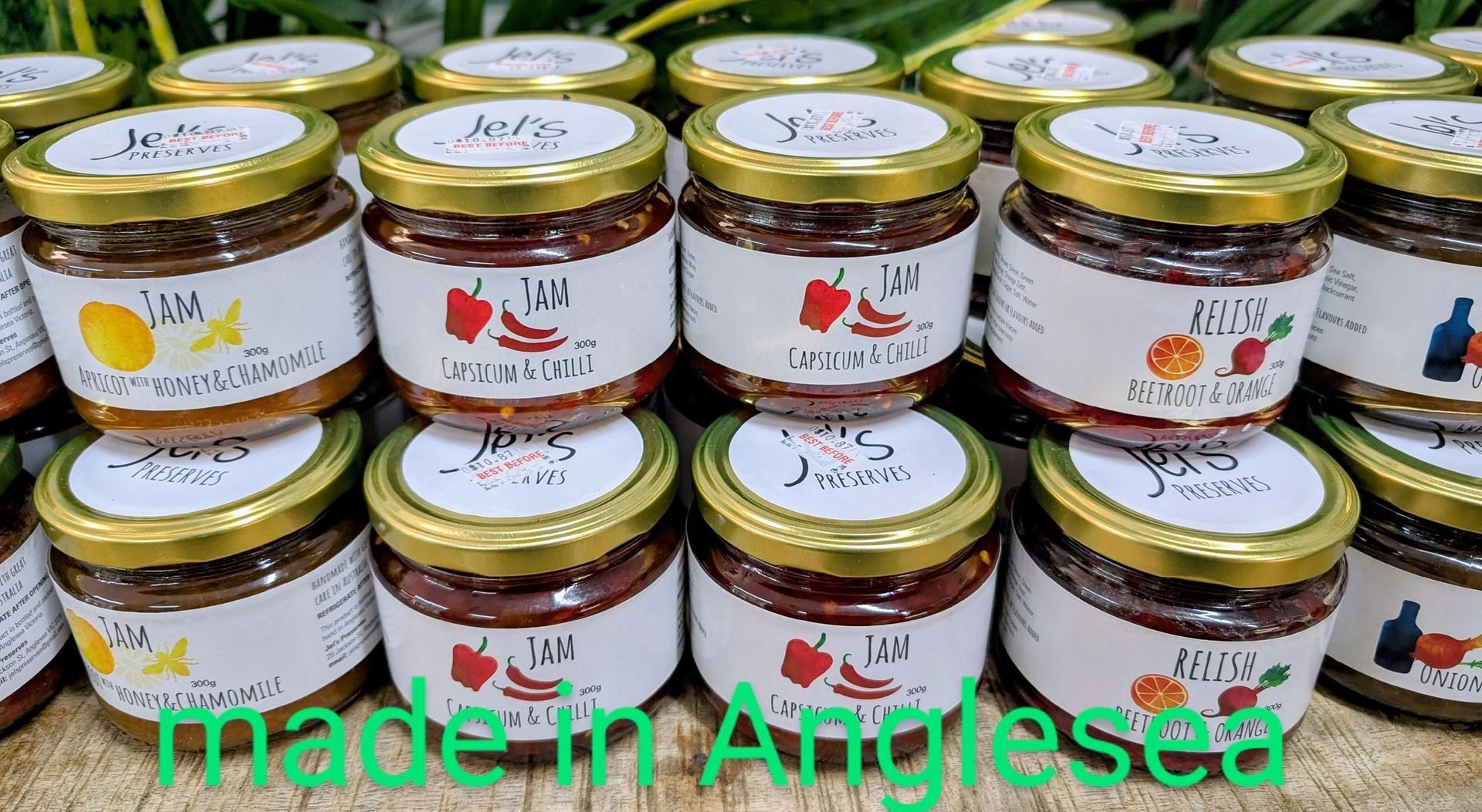 A bunch of jars of jam are stacked on top of each other on a table.