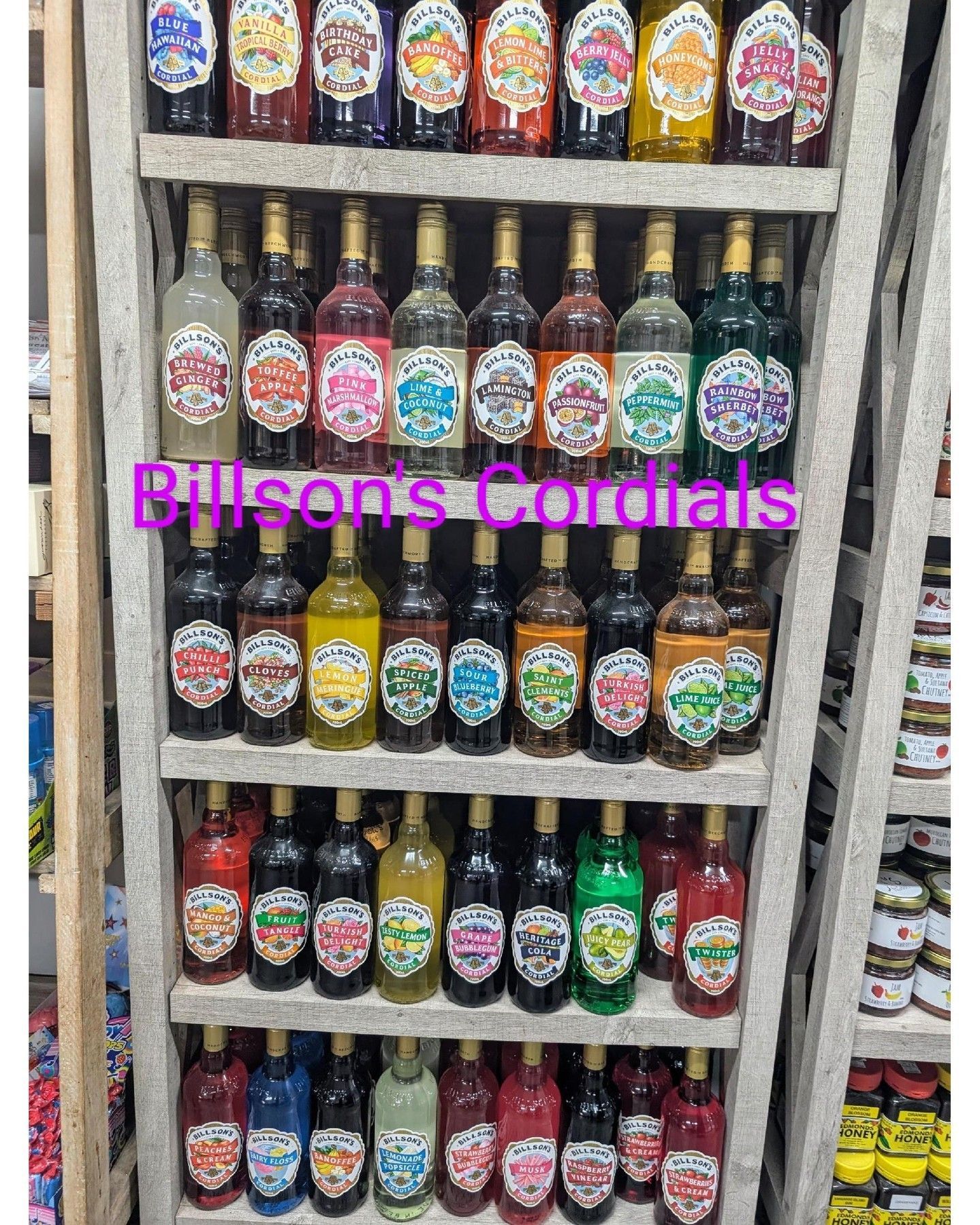 A shelf filled with lots of different colored bottles of liquor.