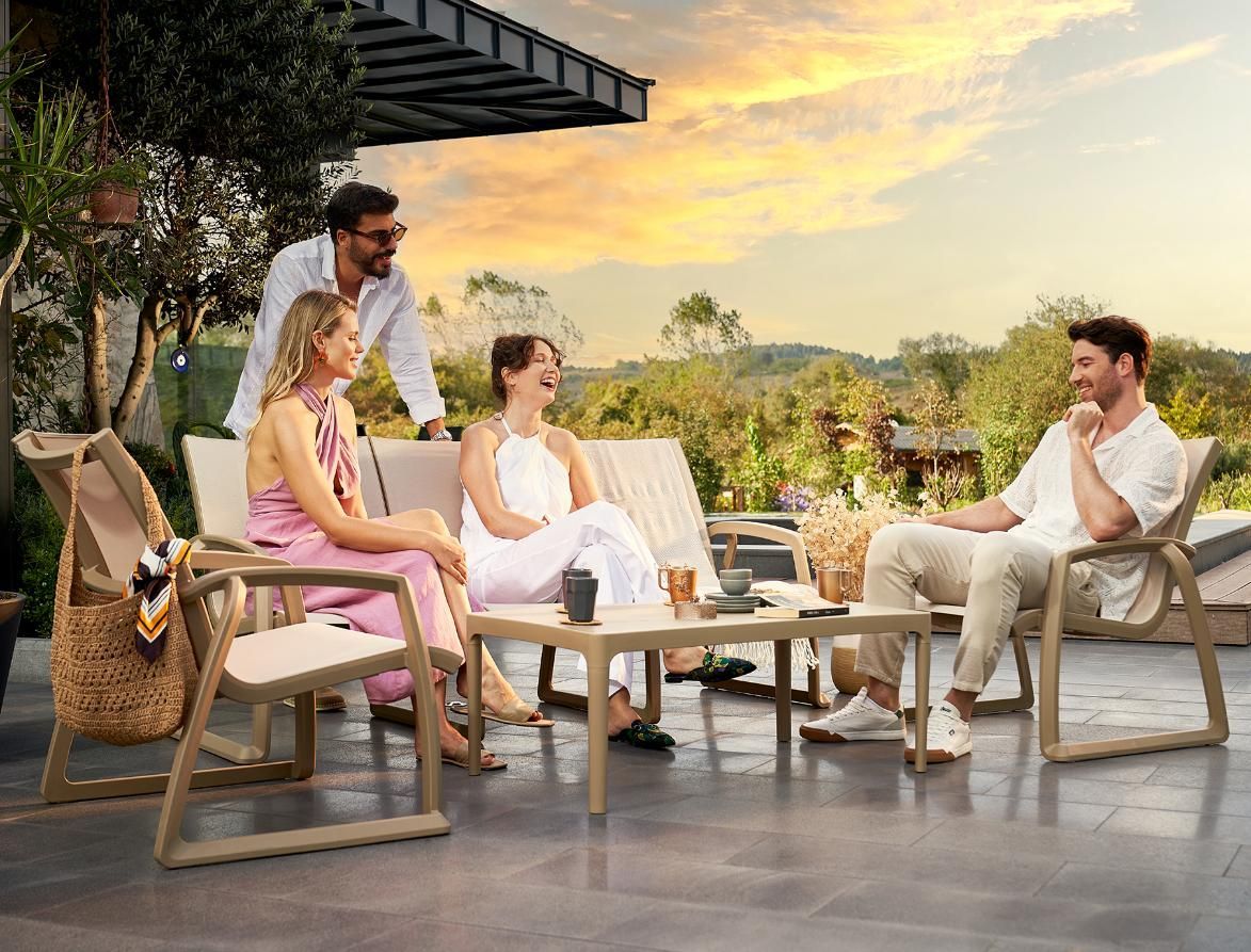 A Group of People Are Sitting on A Patio Talking to Each Other — Creative Commercial Furniture in Gold Coast, QLD