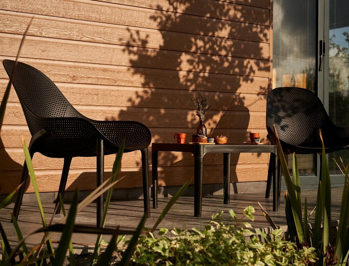 Two Chairs and A Table on A Patio in Front of A House — Creative Commercial Furniture in Gold Coast, QLD
