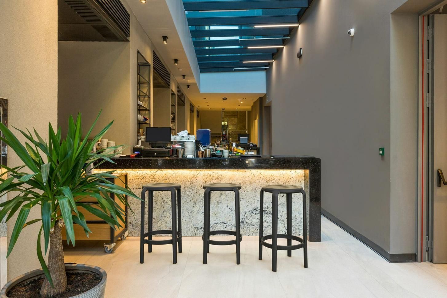 Bar With Stools, a Plant, and a Skylight Above — Creative Commercial Furniture in Cairns City, QLD