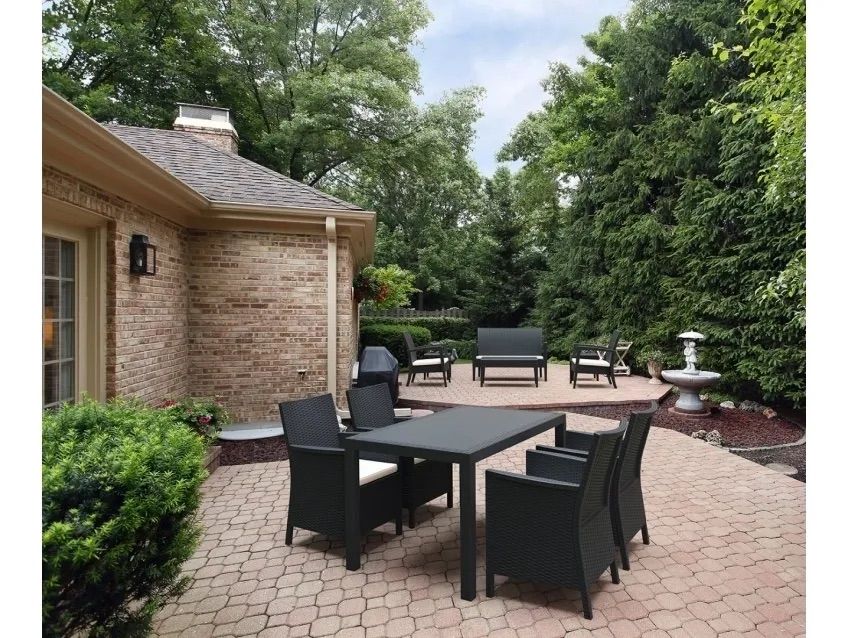 A Patio With a Table and Chairs in Front of a Brick House — Creative Commercial Furniture in Cairns City, QLD 