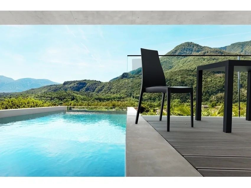 A Chair is Sitting on a Deck Next to a Swimming Pool — Creative Commercial Furniture in Cairns City, QLD 