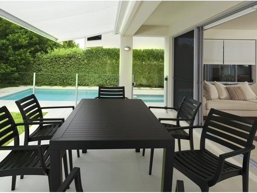 A Table and Chairs on a Patio With a Swimming Pool in the Background β Creative Commercial Furniture in Cairns City, QLD