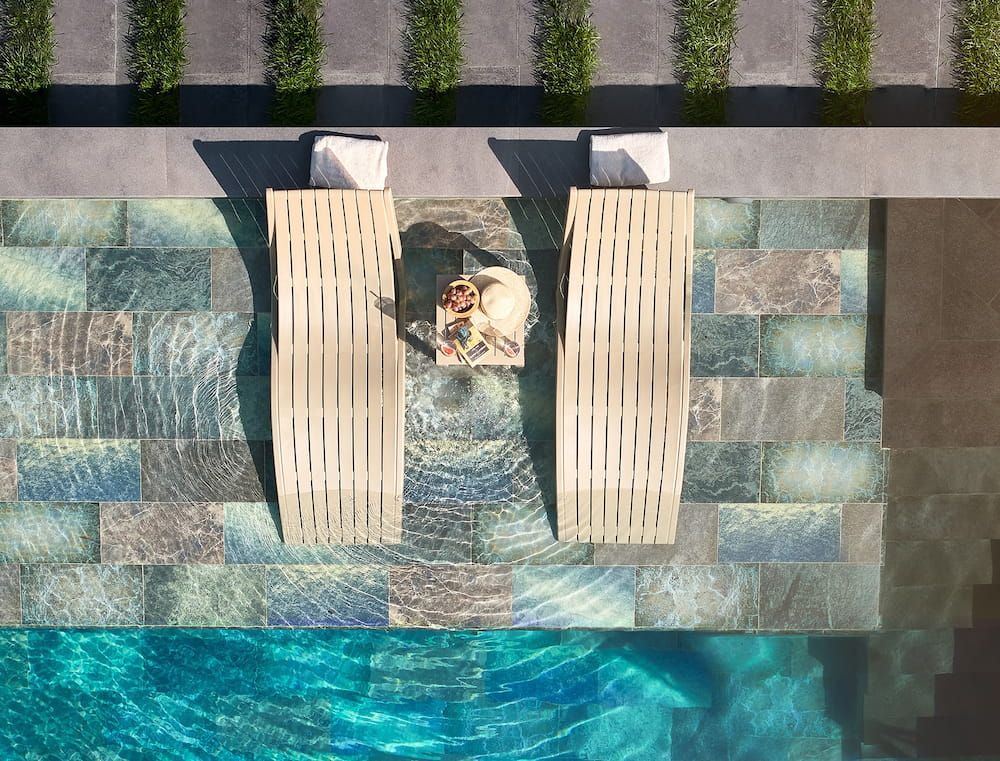 An Aerial View of Two Lounge Chairs Next to a Swimming Pool — Creative Commercial Furniture in Cairns City, QLD