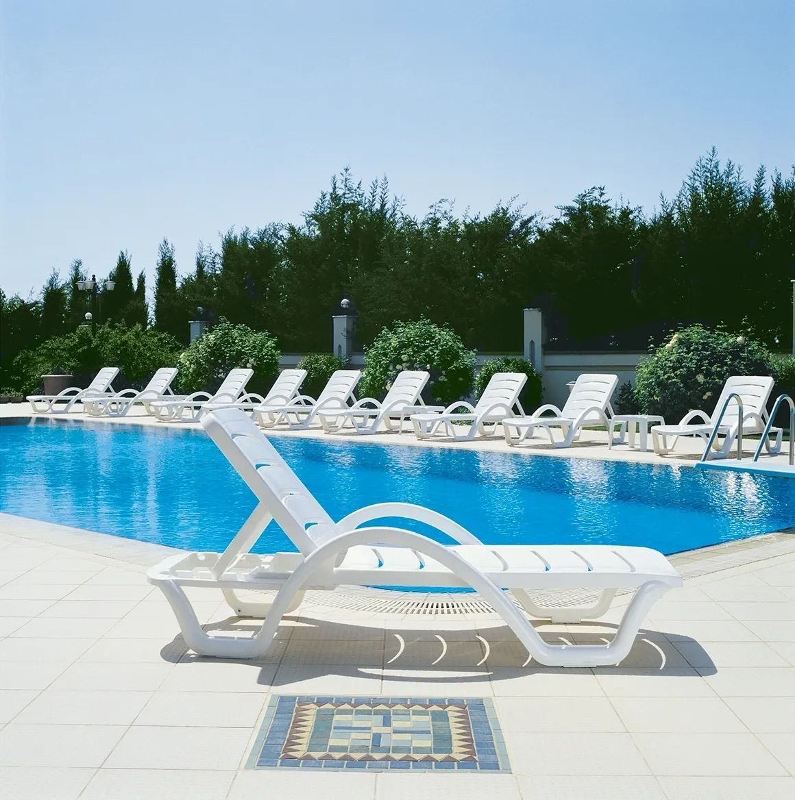 A Row of White Lounge Chairs Next to a Swimming Pool β Creative Commercial Furniture in Cairns City, QLD