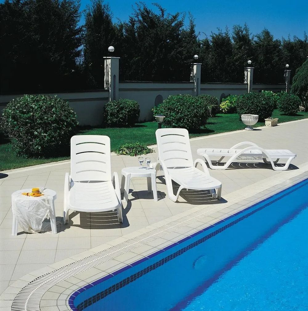 White Lounge Chairs Beside a Pool — Creative Commercial Furniture in Cairns City, QLD