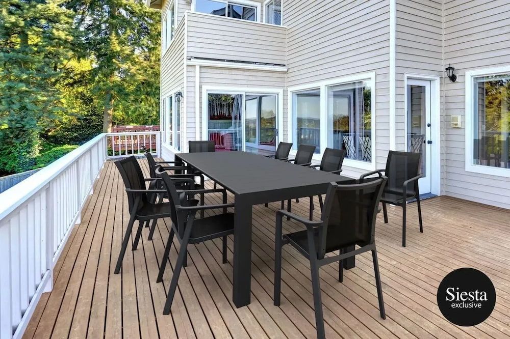 A Large Table and Chairs Are on a Deck in Front of a House — Creative Commercial Furniture in Cairns City, QLD 
