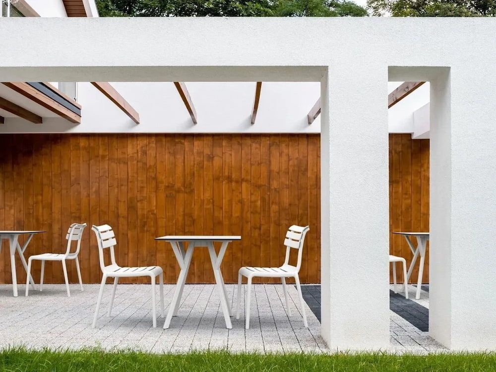 A Patio With Tables and Chairs Under a Pergola — Creative Commercial Furniture in Cairns City, QLD 