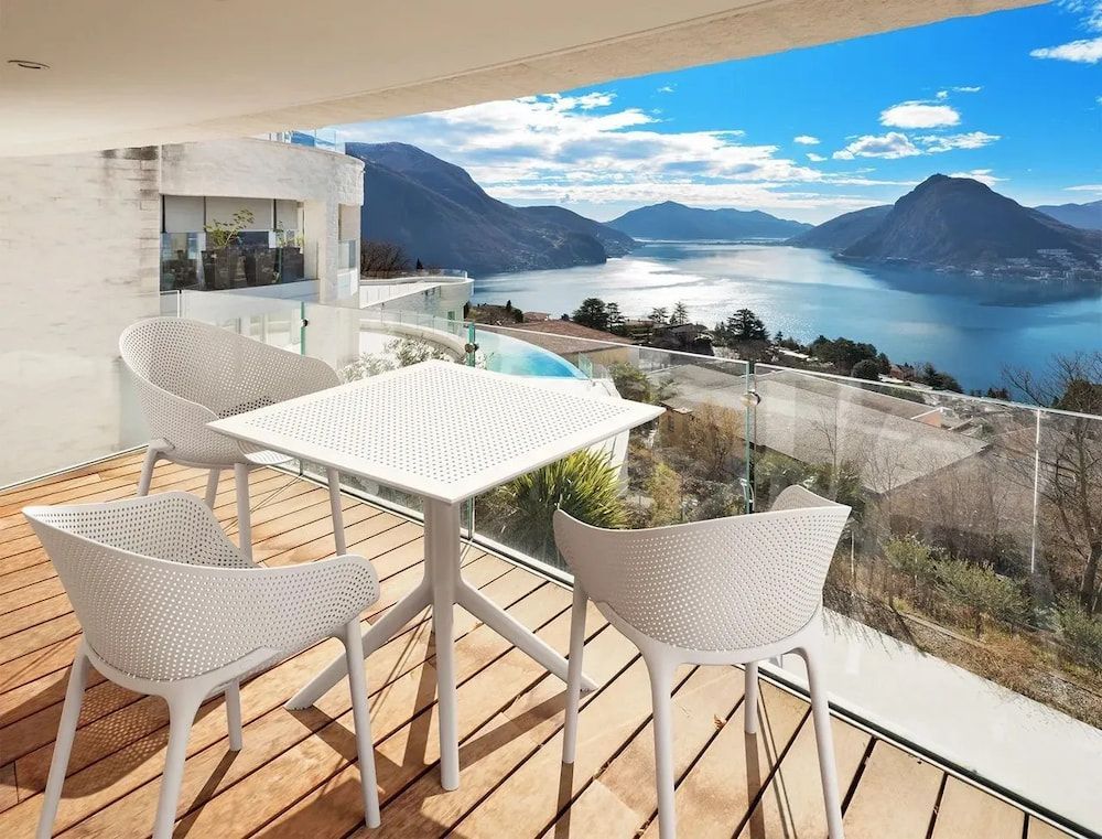 White Patio Furniture on a Balcony Overlooking a Lake and Mountains — Creative Commercial Furniture in Cairns City, QLD
