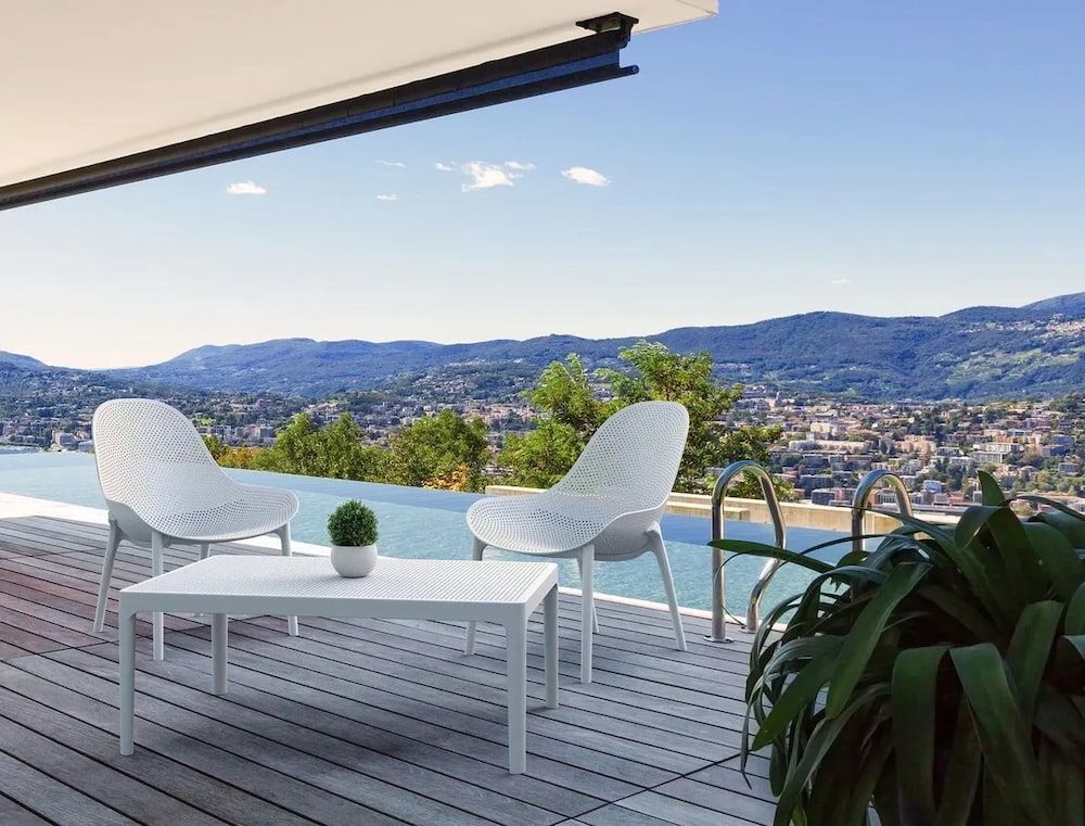 A Deck With Chairs and a Table Overlooking a Swimming Pool — Creative Commercial Furniture in Cairns City, QLD 