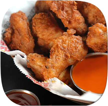 A basket of golden fried chicken wings served with tangy dipping sauce