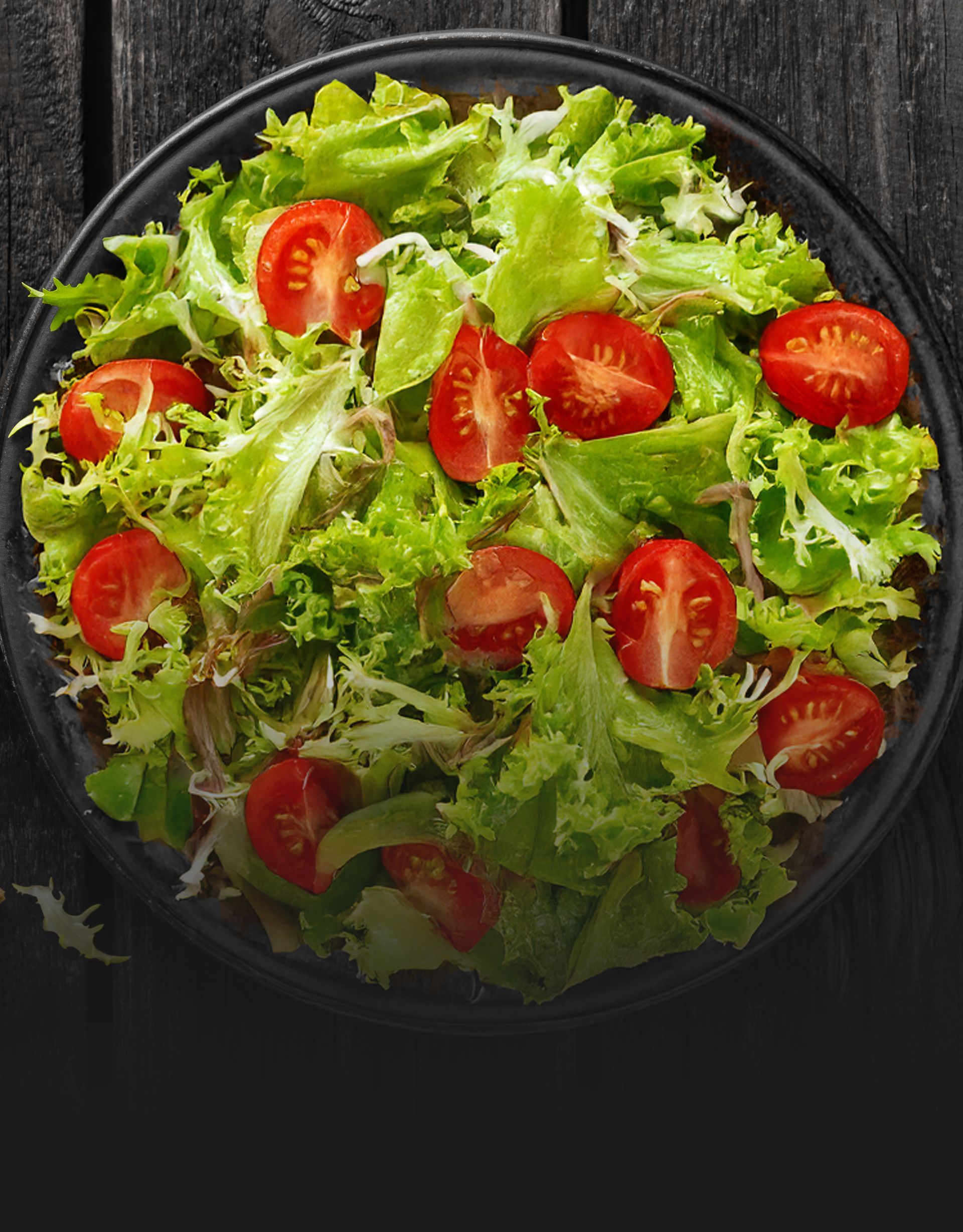 A close up of a salad on a plate on a table.