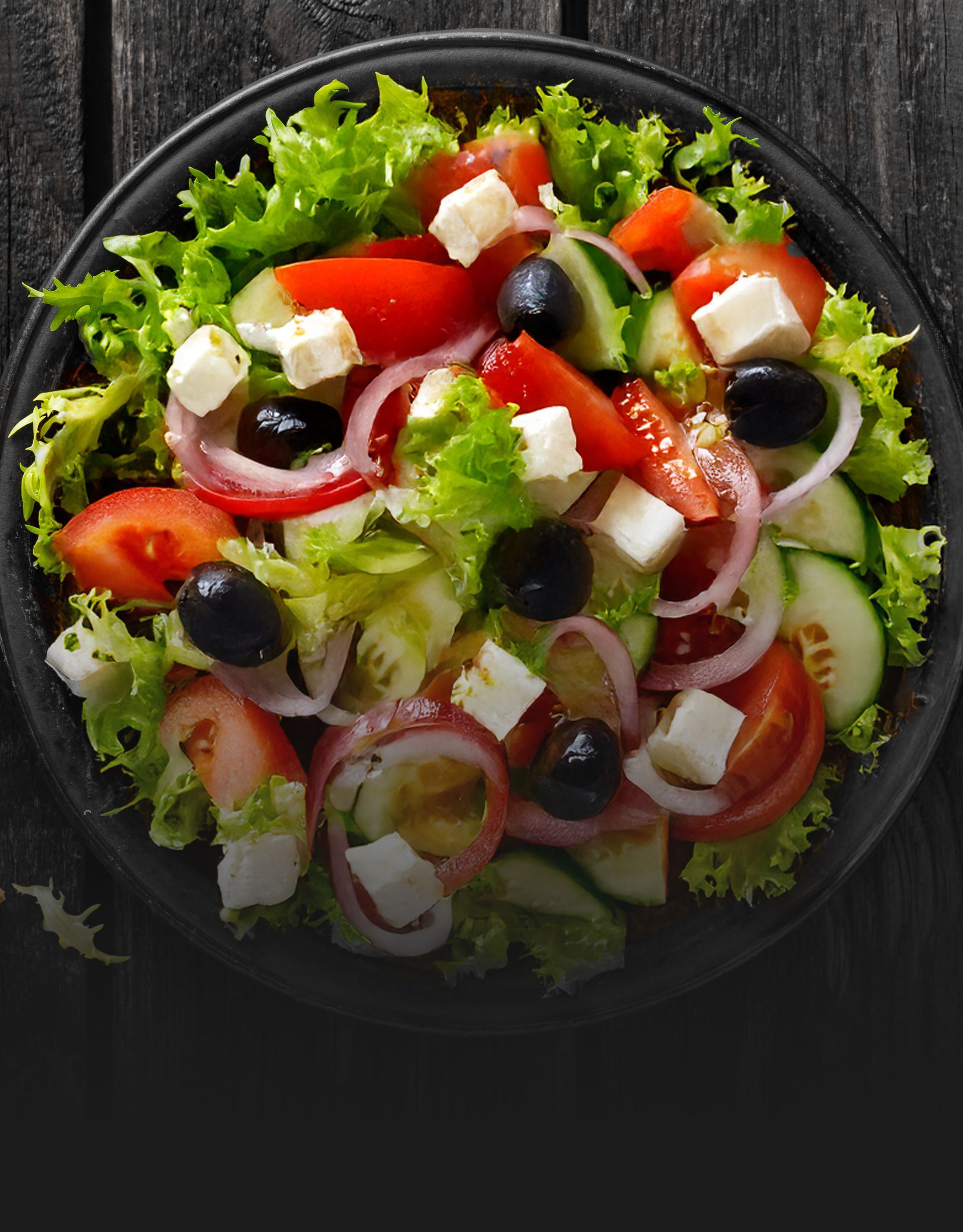 A close up of a salad on a plate on a table.