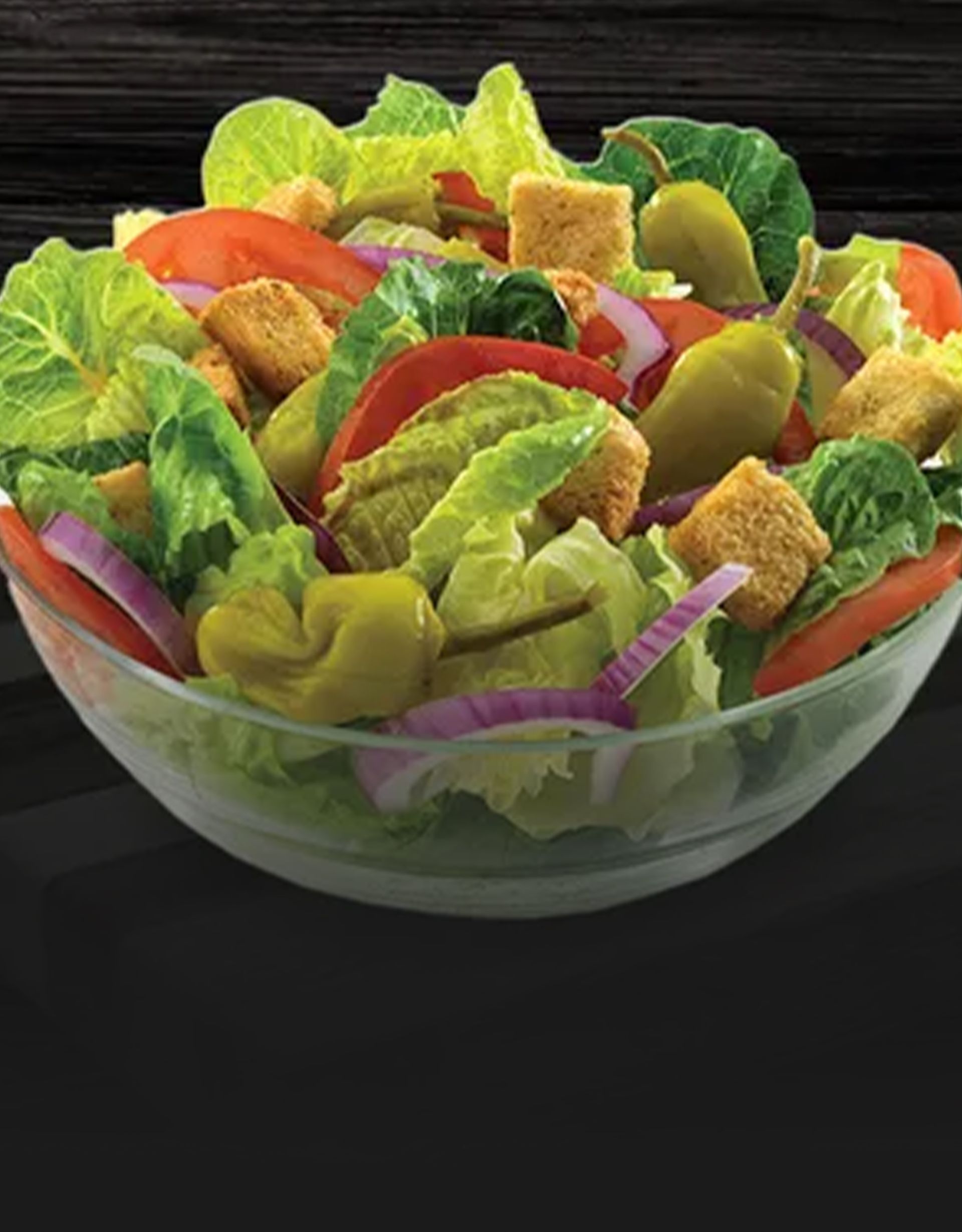 A close up of a salad on a plate on a table.