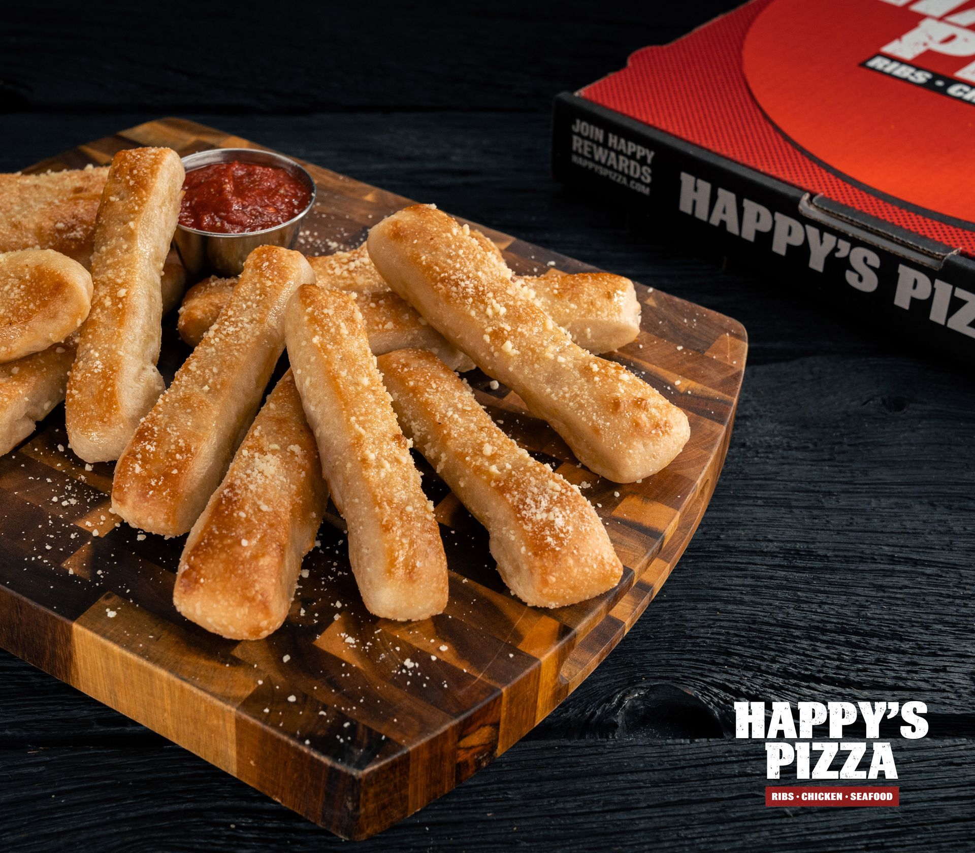 A wooden cutting board topped with cheese sticks from happy 's pizza