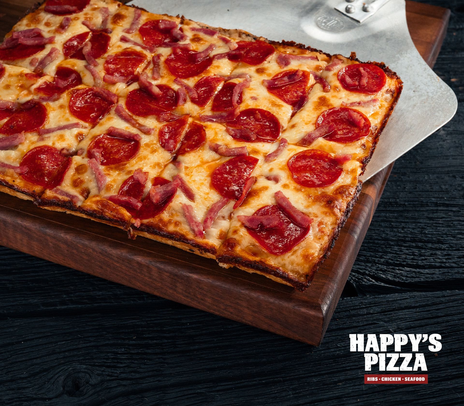 A pizza from happy 's pizza is sitting on a wooden cutting board