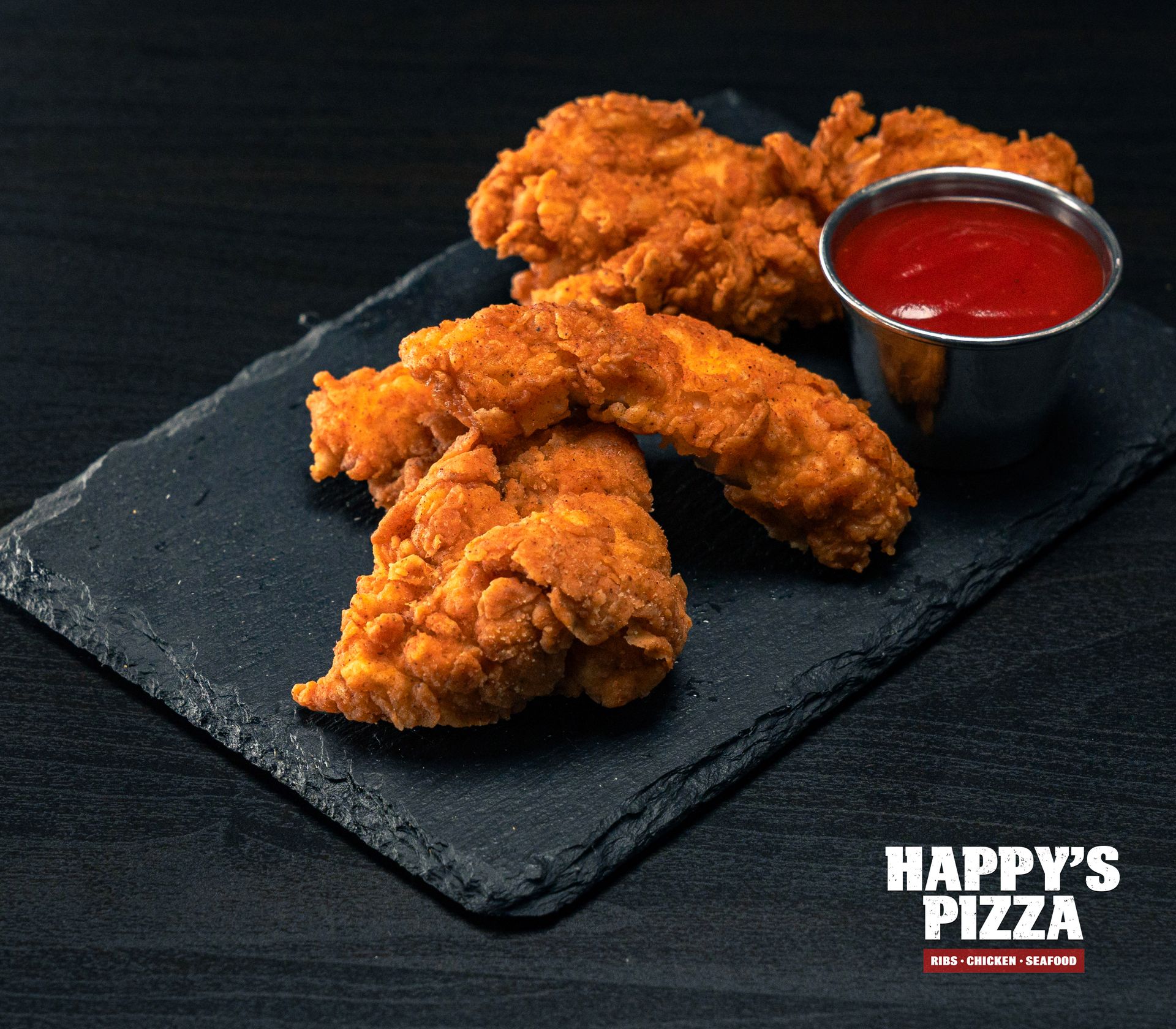 A tray of fried chicken fingers with ketchup from happy 's pizza