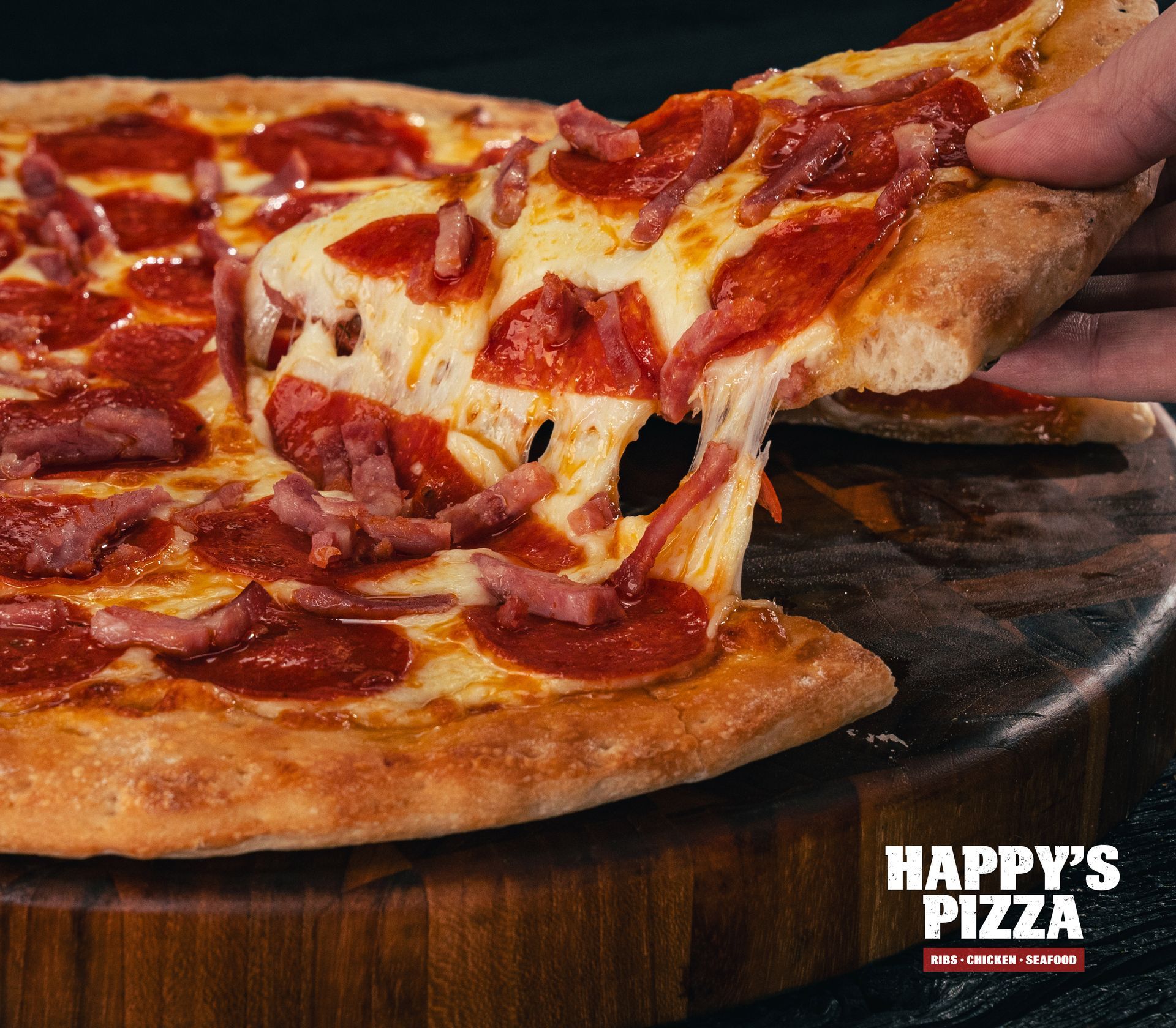A person is taking a slice of pepperoni pizza from happy 's pizza.