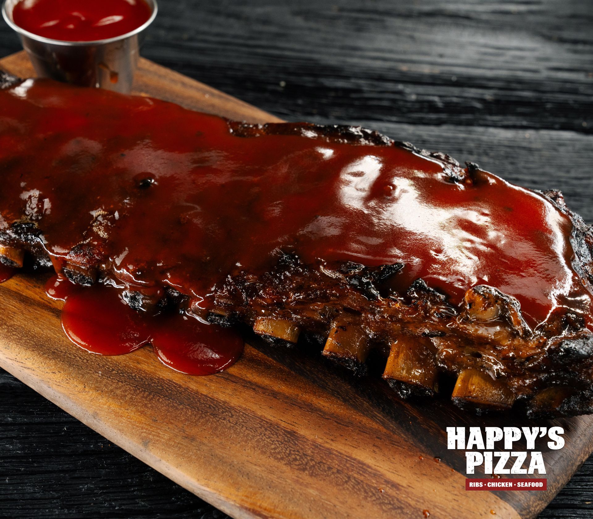A happy 's pizza advertisement with ribs on a wooden cutting board