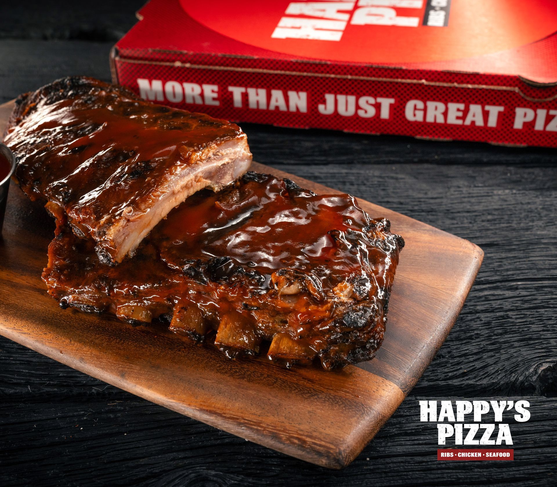 A happy 's pizza advertisement with ribs on a wooden cutting board