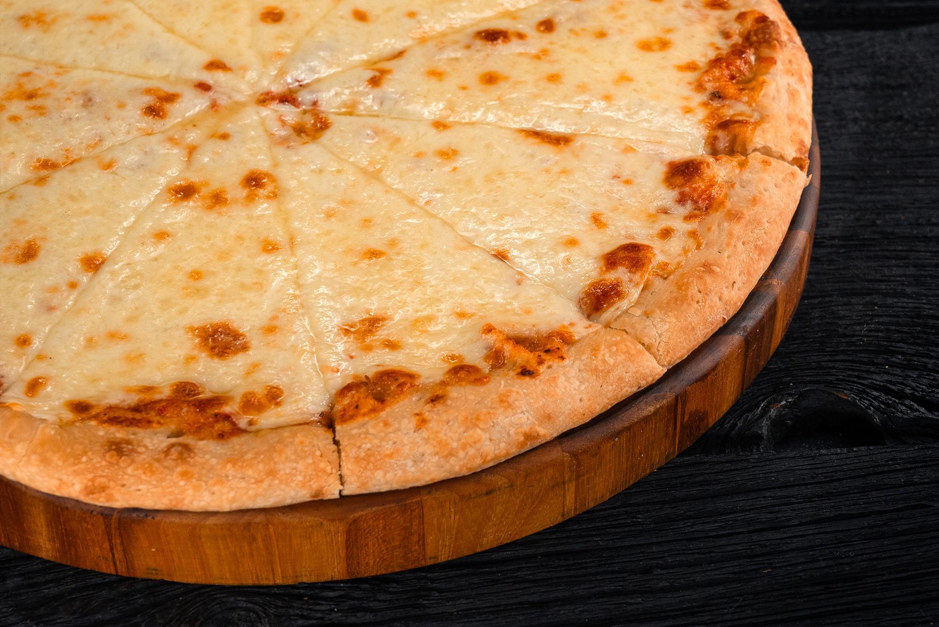 Detroit-style cheese pizza with a golden crust on a wooden cutting board