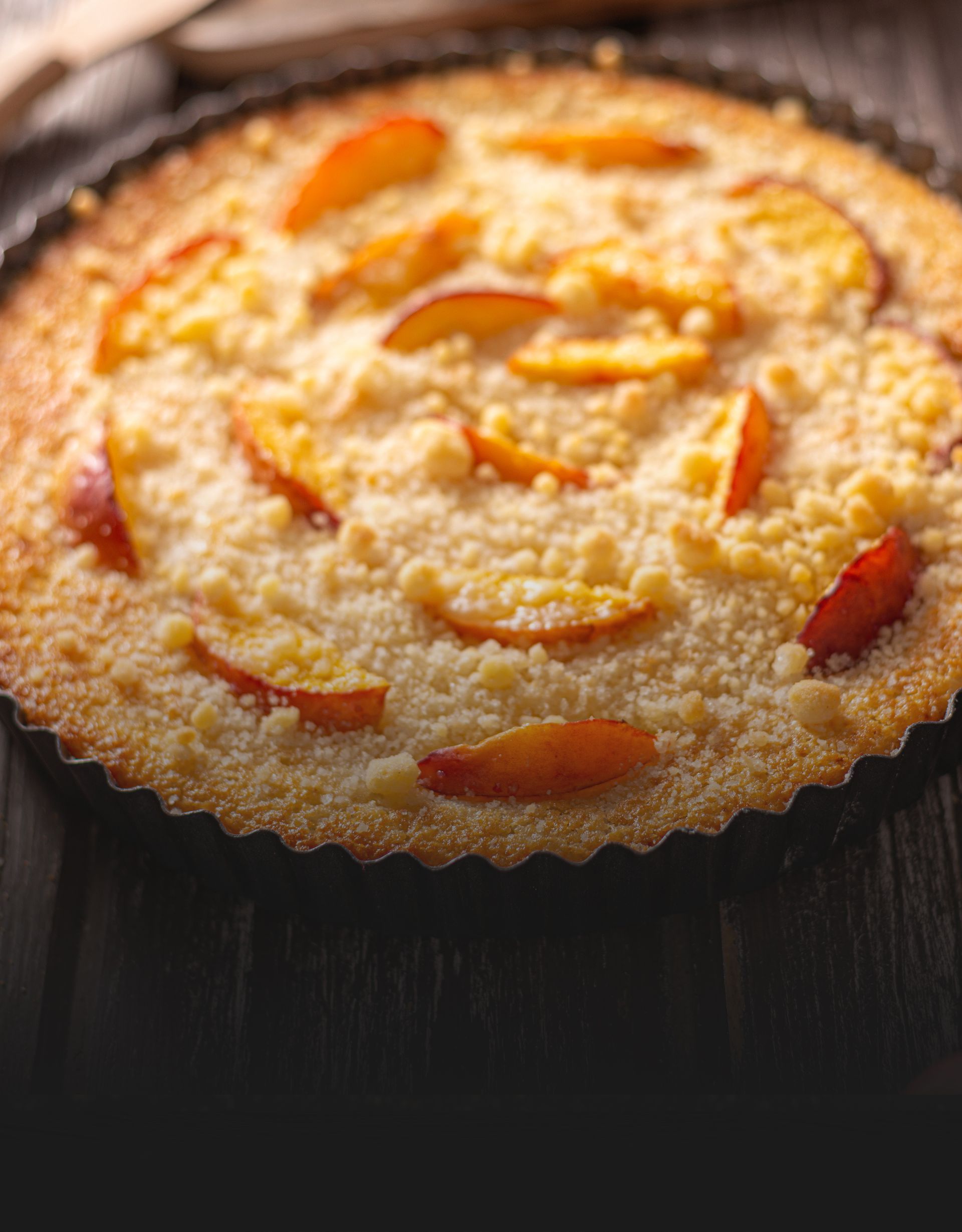 A close up of a peach pie on a wooden table.