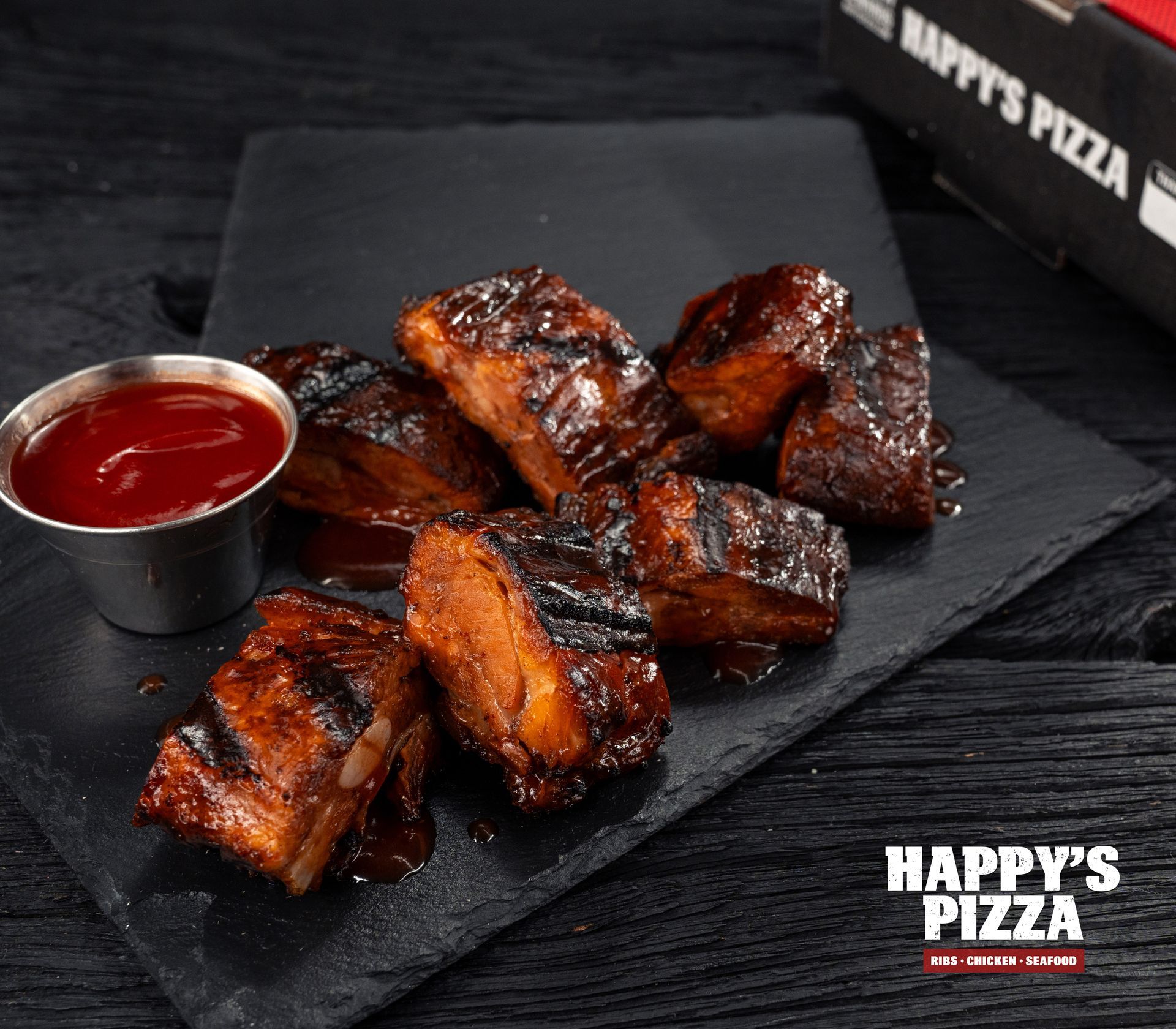 A plate of ribs with ketchup from happy 's pizza