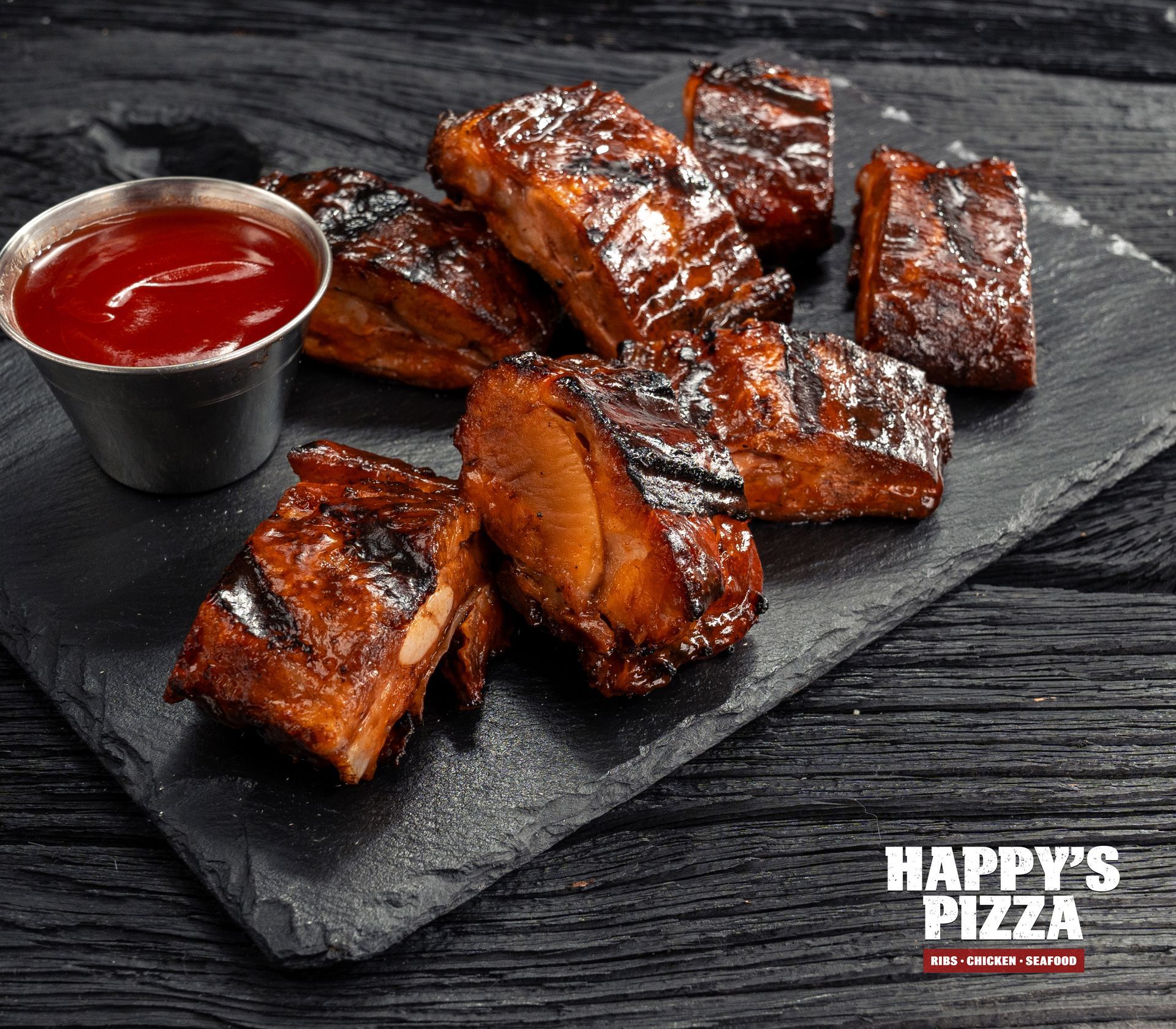 A tray of ribs and ketchup from happy 's pizza