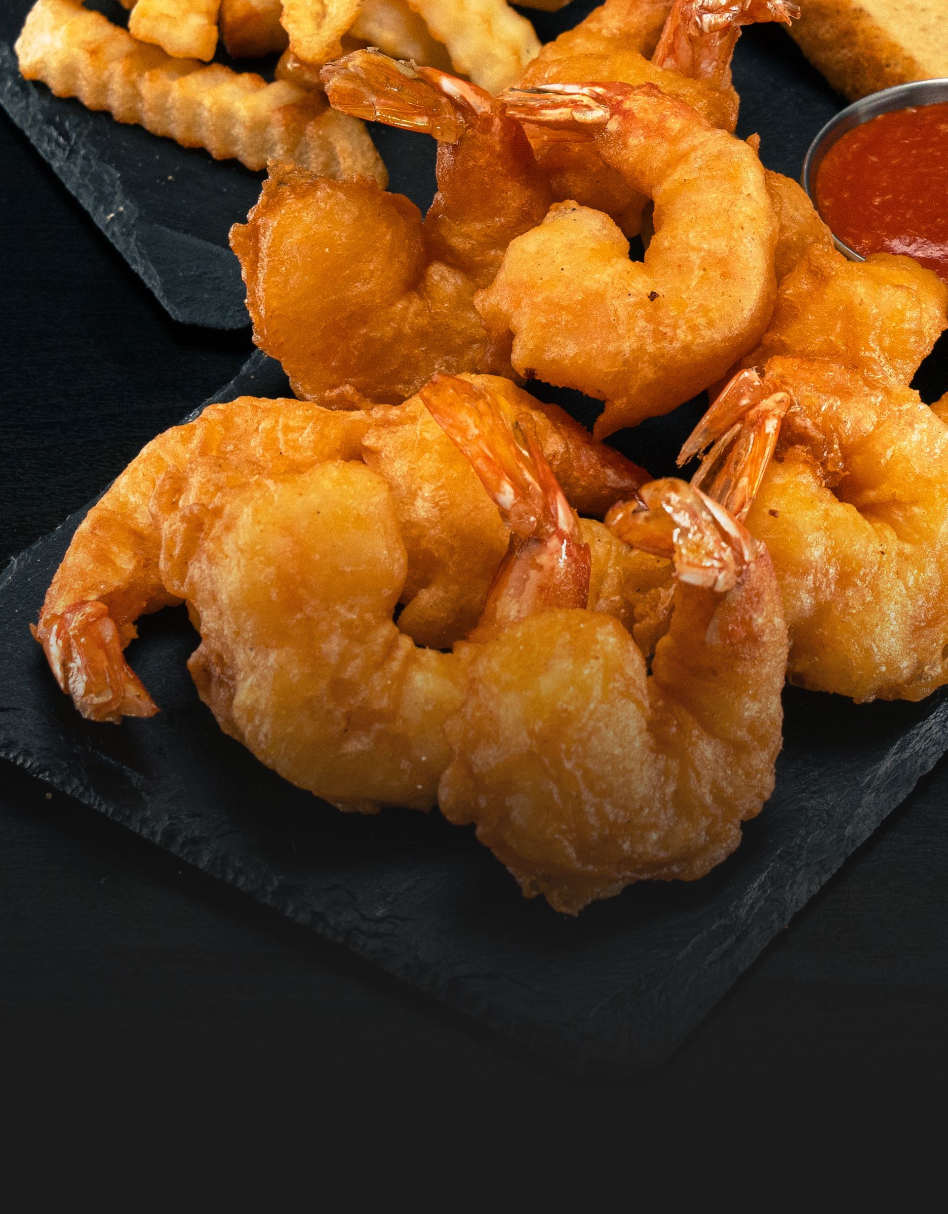 A plate of fried shrimp and french fries on a table.