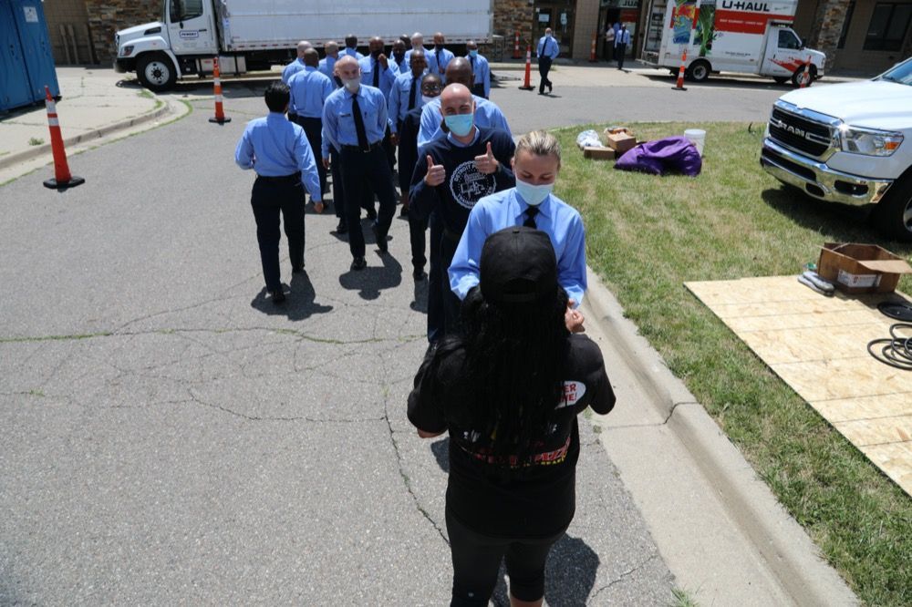 A group of people wearing masks are walking down a street.