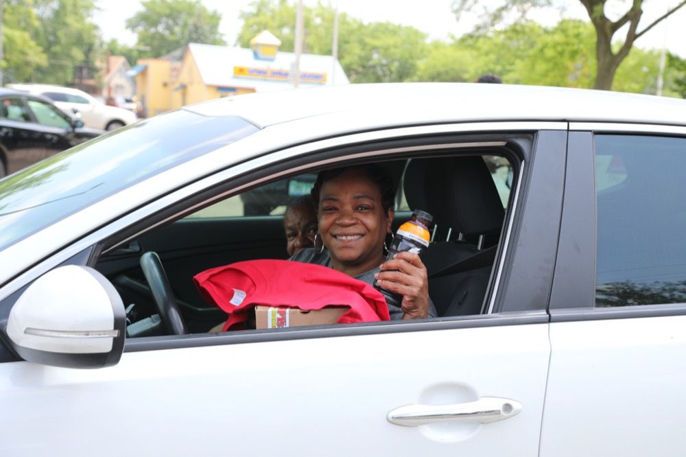 A woman is sitting in a car holding a bottle of soda.