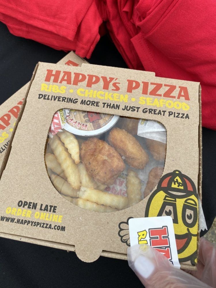 A person is holding a box of happy 's pizza