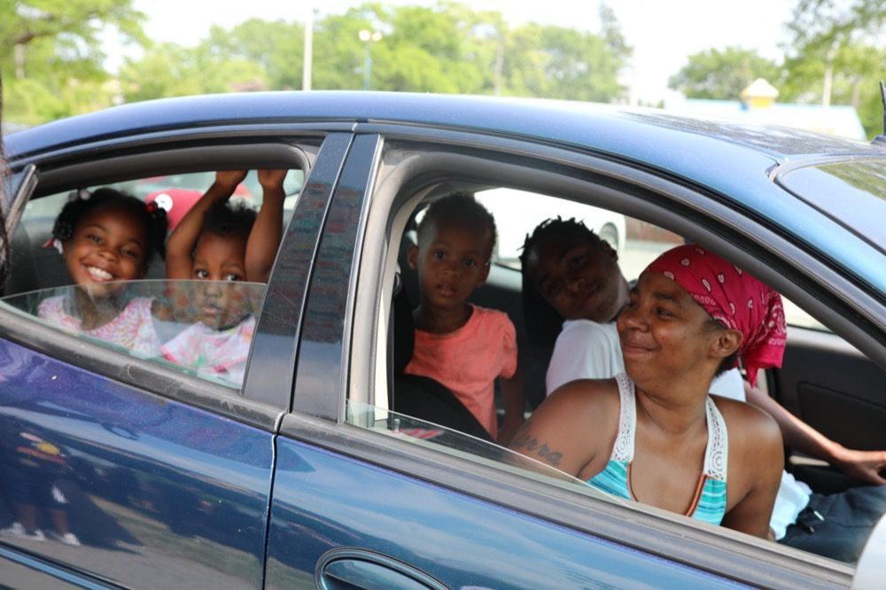 A woman and three children are sitting in a car.