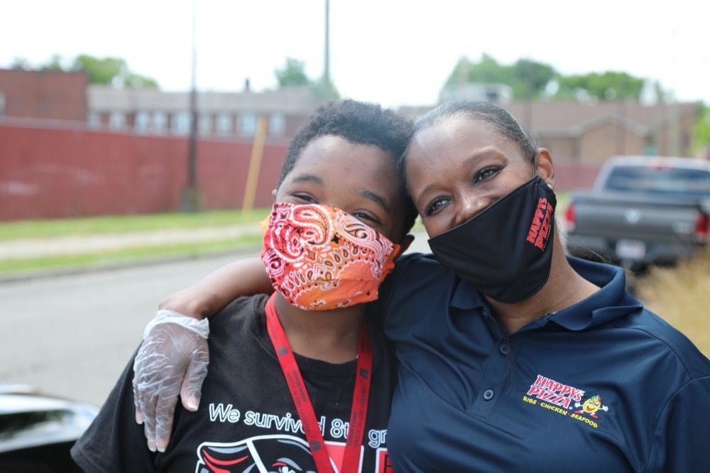 A woman and a boy wearing face masks are posing for a picture.